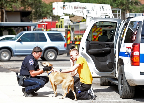 Midland Police Department officer Tyler Thompson returns a dog named Leo to his owner, Austen Lawler, after the animal was rescued by Midland firefighters from an apartment fire at The Annex apartments on Friday, Oct. 16, 2015. James Durbin/Reporter-Telegram